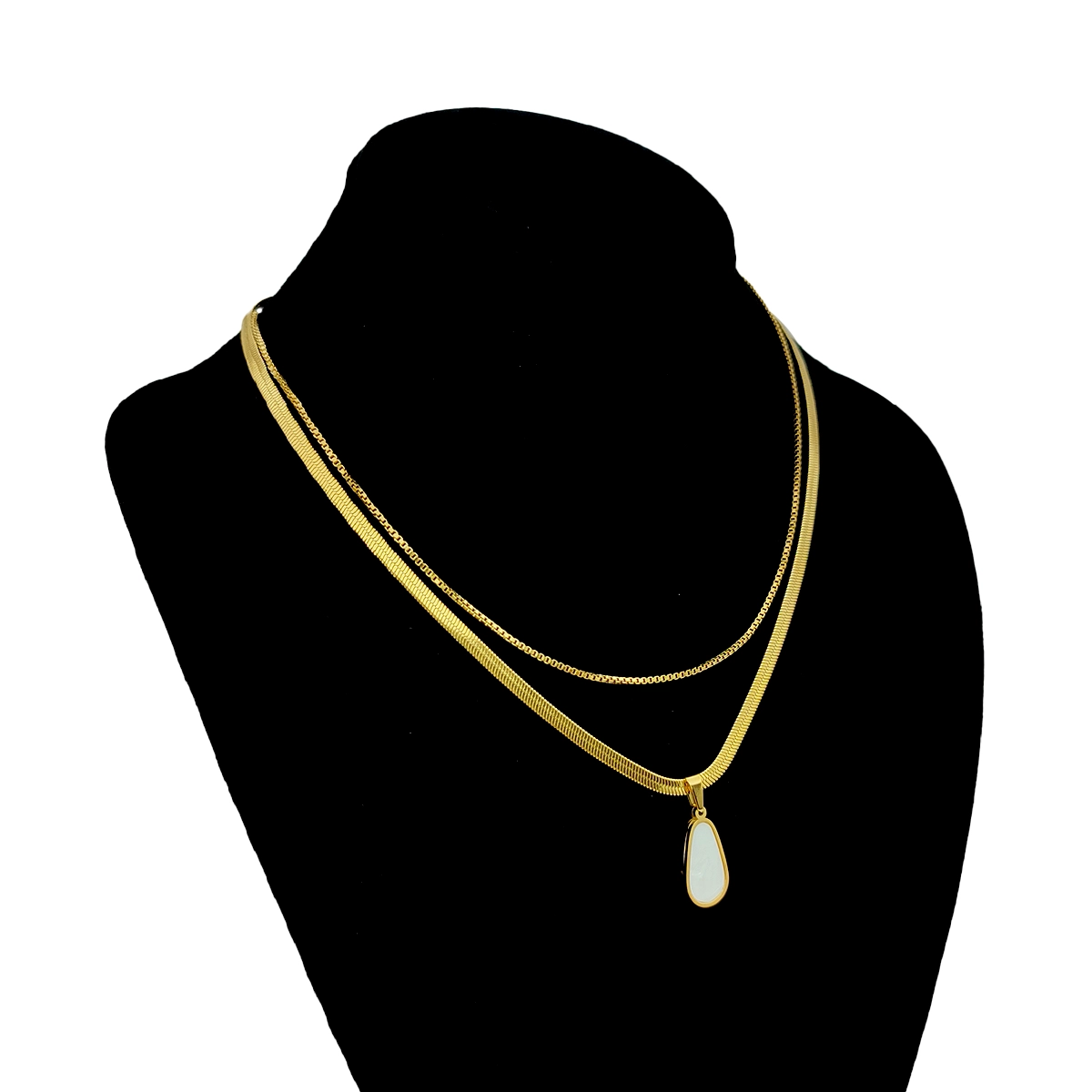 Collar Acero Dorado Doble Cadena Dije Gota Madre Perla 7 Collar dorado de doble cadena en acero inoxidable con dije tipo gota de madre perla sobre exhibidor negro de busto en fondo blanco