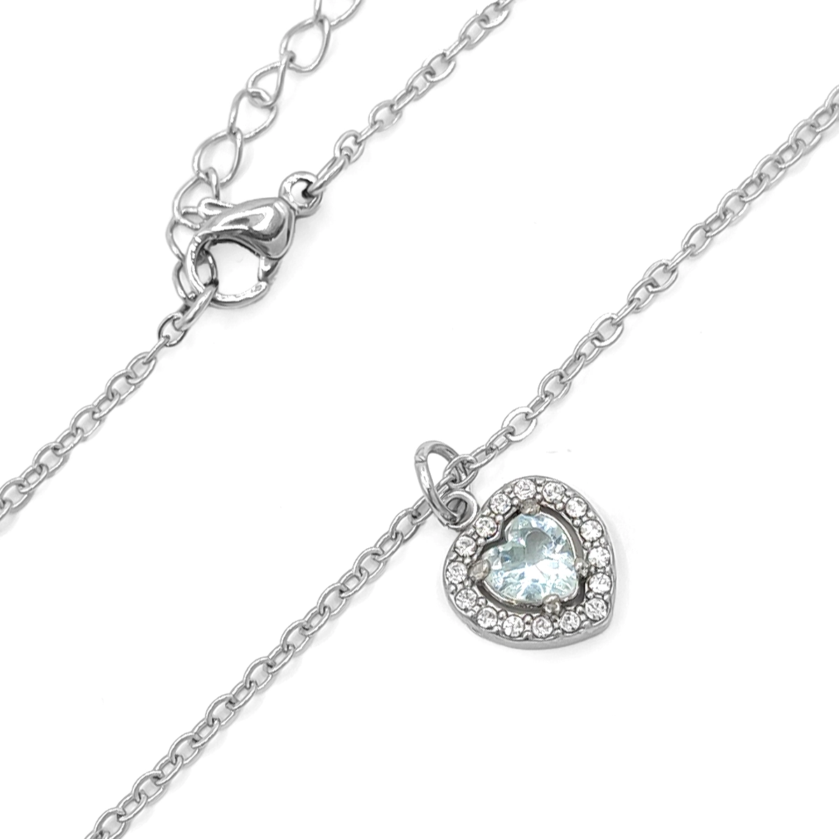 Collar plateado de acero inoxidable con dije de corazón de 1 x 1 cm, zirconia azul central y cristales sobre fondo blanco