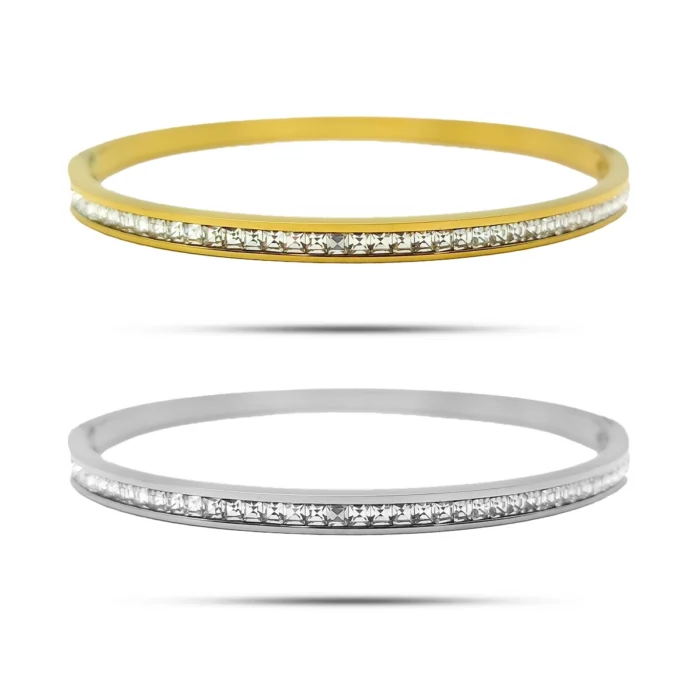 Brazalete delgado de acero inoxidable con fila de cristales cuadrados en acabado dorado y plateado sobre fondo blanco