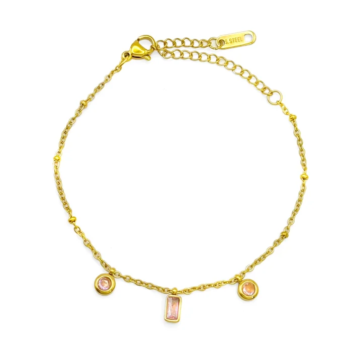 Pulsera dorada de acero inoxidable con cristales rosas rectangulares y circulares, mini balines y cadena delgada sobre fondo blanco
