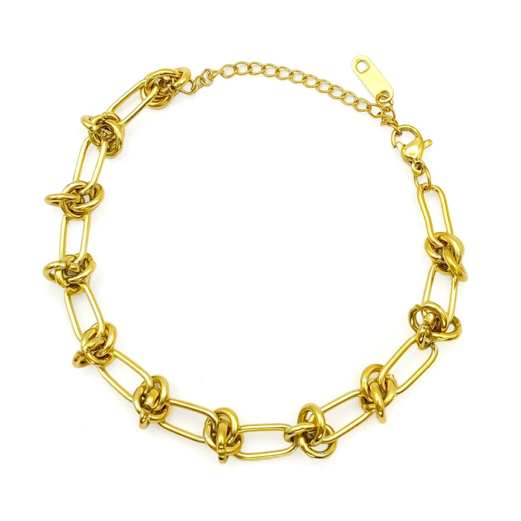 Pulsera dorada de acero inoxidable con eslabones ovales y nudos sobre fondo blanco