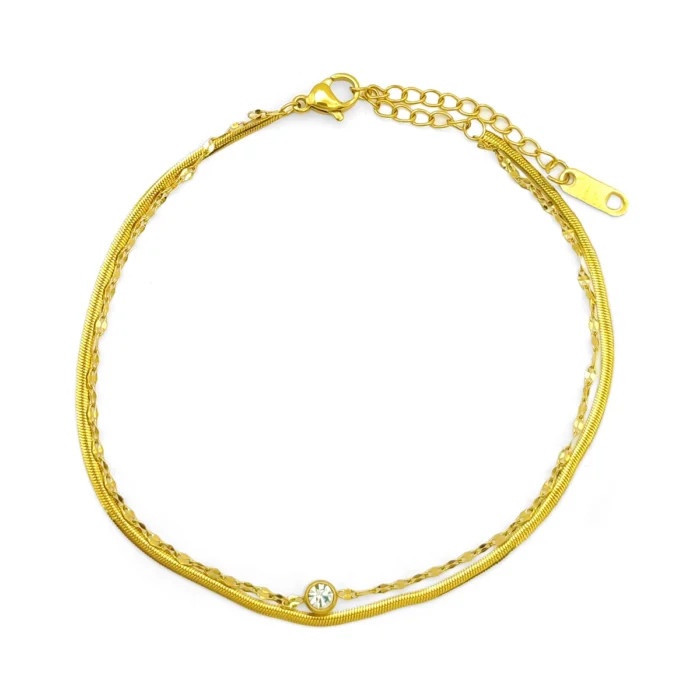 tobillera doble dorada con cristal en acero inoxidable, cadena planchada y petatillo sobre fondo blanco